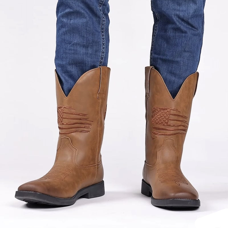Person wearing blue jeans and brown leather cowboy boots with an American flag design.