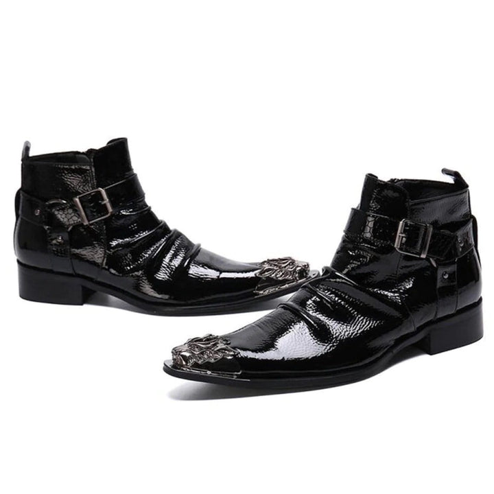 Pair of black patent leather ankle boots with silver embellishments.