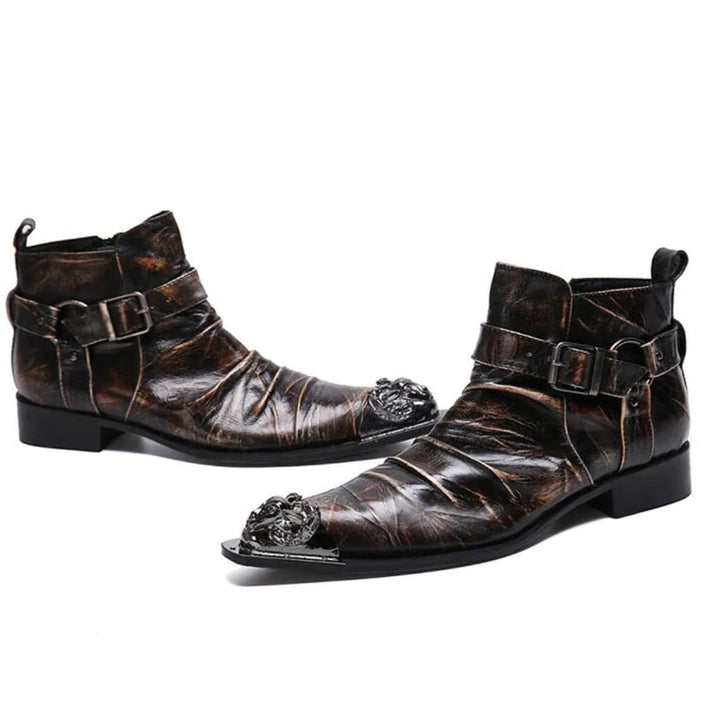 Two brown leather ankle boots with buckle straps and ornate metal toe caps. 
